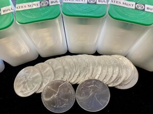 A group of silver coins in a plastic container.