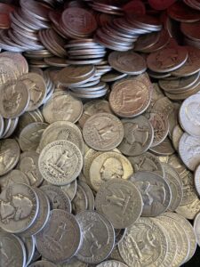 A group of silver coins in a plastic container.